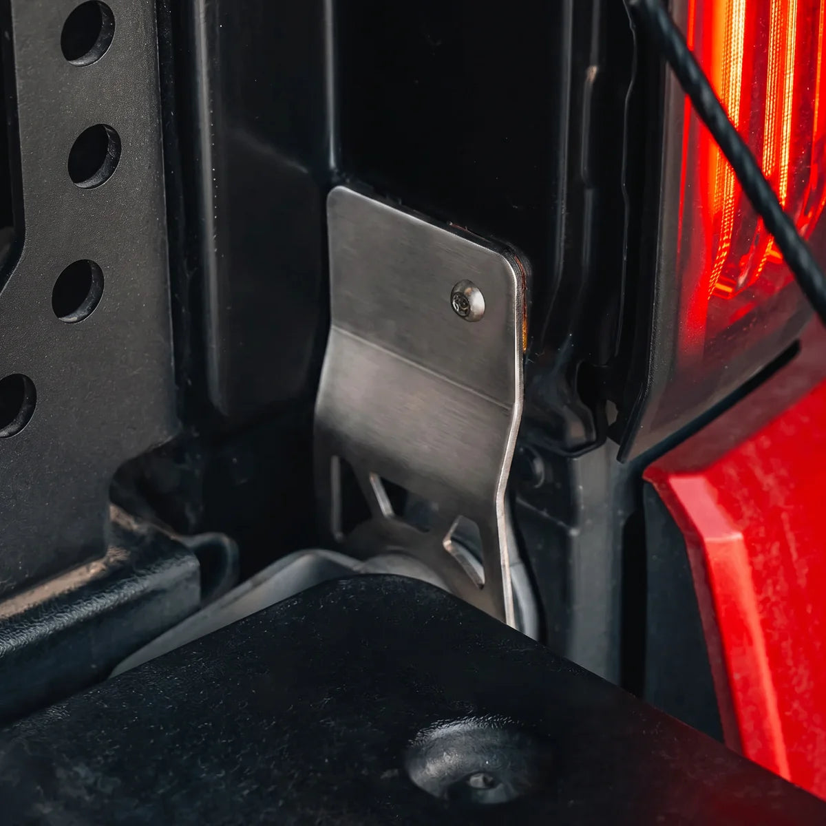 CALI RAISED tailgate protector installed beside the passenger-side Tacoma hinge