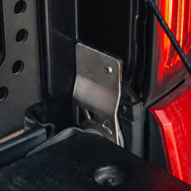 CALI RAISED tailgate protector installed beside the passenger-side Tacoma hinge
