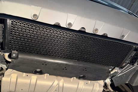 CSF performance oil cooler installed behind BMW front bumper reinforcement showing airflow position and factory-style integration