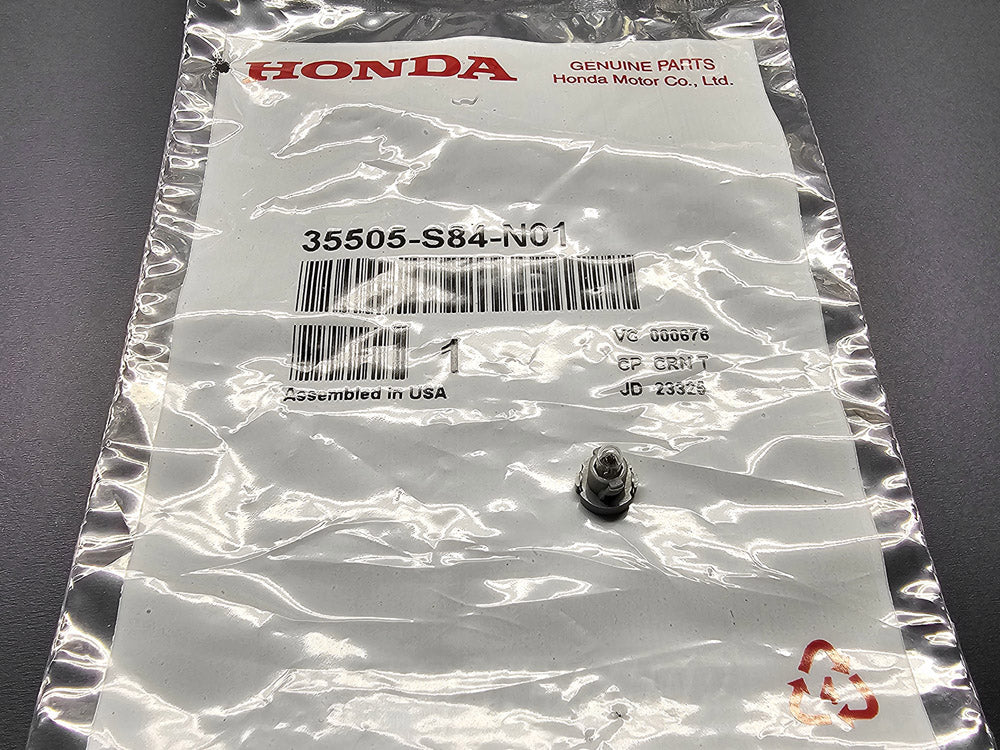 OEM Honda interior clock light bulb T3 neo-wedge with base shown on Honda packaging