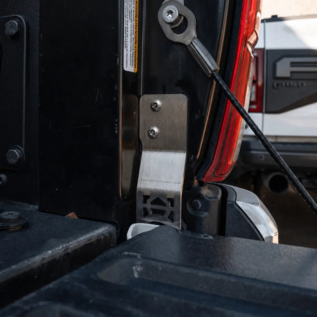 CALI RAISED two-bolt tailgate protector installed at passenger-side Tacoma hinge