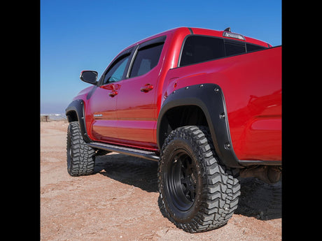 Husky matte-black Pocket Style fender flares for 2005–2011 Toyota Tacoma with 5-foot bed - unpainted on red truck.