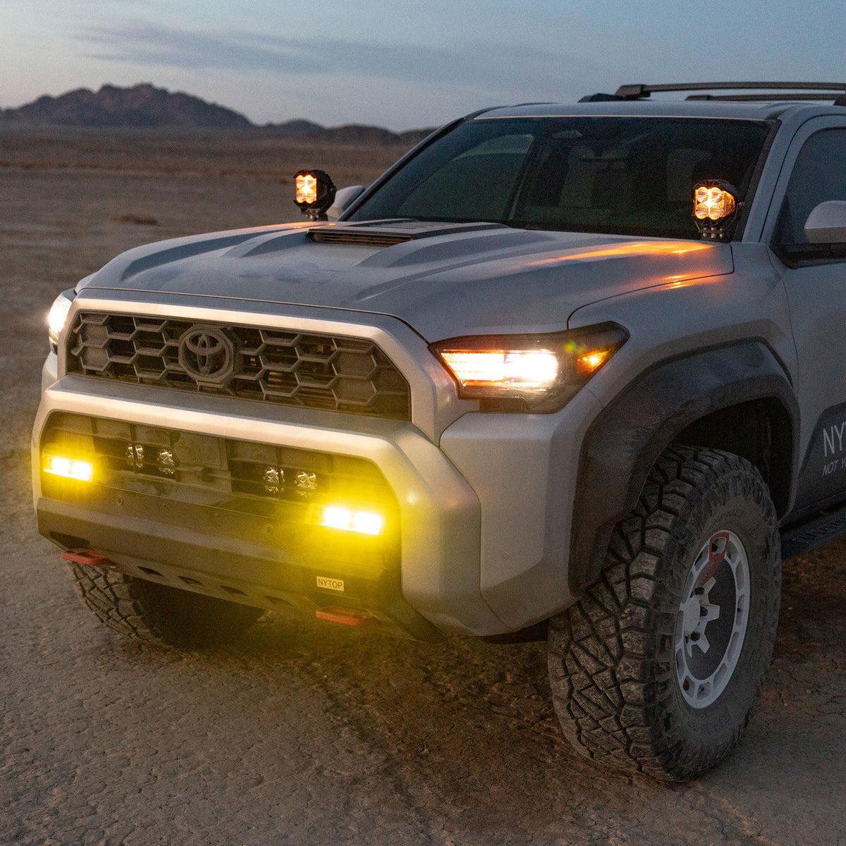Toyota Tacoma with amber bumper and A-pillar off-road lights illuminated