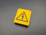 Angled view of 3D-printed yellow M18 battery terminal cover