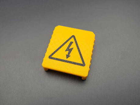 Angled view of 3D-printed yellow M18 battery terminal cover
